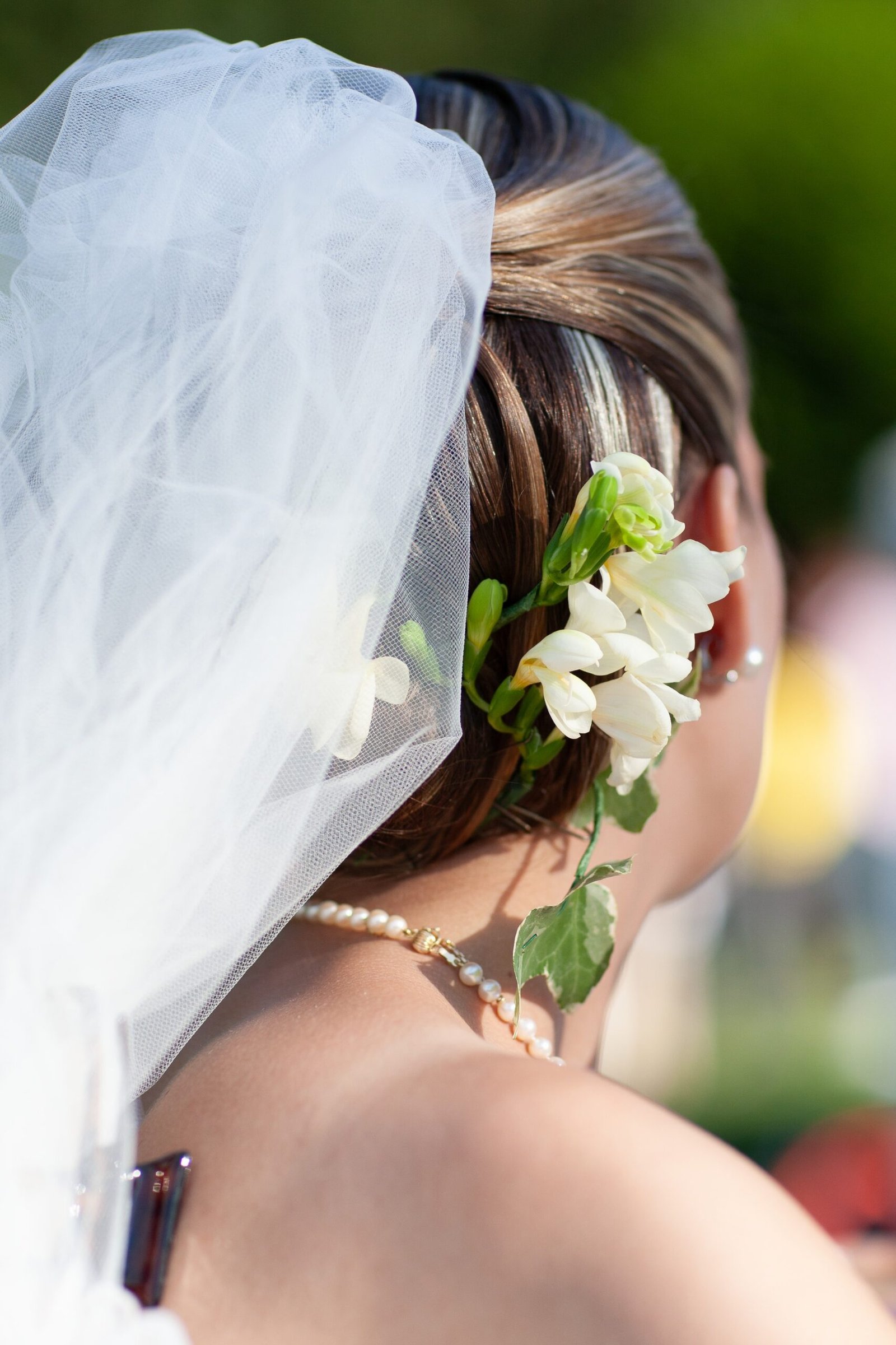 mariée de dos avec une fleur sur sa coiffure